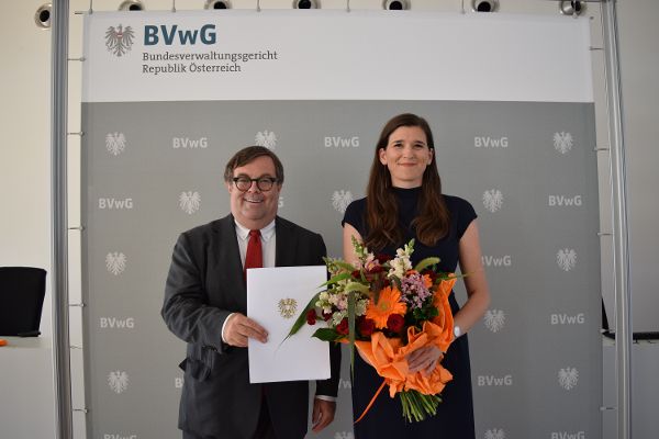 Daniela Urban und Christian Filzwieser bei der Dekretübergabe mit Urkunde und Blumenstrauß
